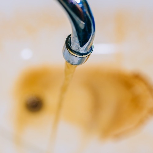 rusty water flowing from a leaking faucet