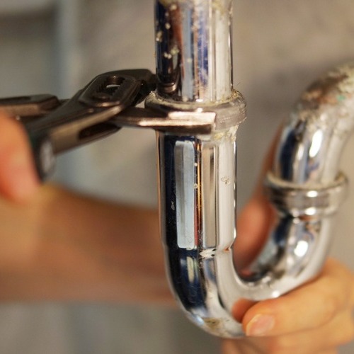 close-up of a plumber repairing a pipe