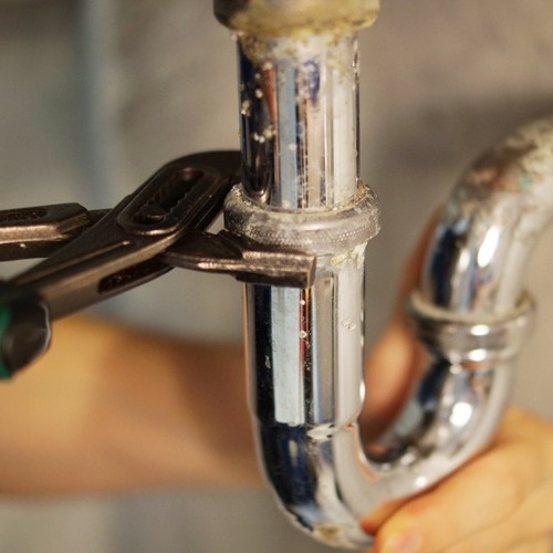 close-up of a pipe being repaired with a wrench